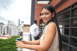 African business smart woman stands at outdoor terrace building. people with on hand in good feeling with city space building. relaxing of people business morning. photo