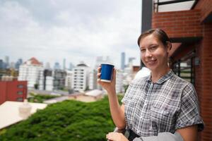 African business smart woman stands at outdoor terrace building. people with on hand in good feeling with city space building. relaxing of people business morning. photo