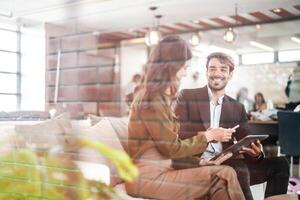 Business people talking at workplace office. Male and female colleagues enjoy relaxing and sitting on sofa. colleagues discussing about the project in the office. team of young people in office. photo