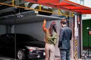 Professional salesperson woman selling cars to businessman buyer. Car Sales. Manager Giving suggestions to Businessman Buyer In garage parking Dealership Shop. Car dealer sales consultant. photo