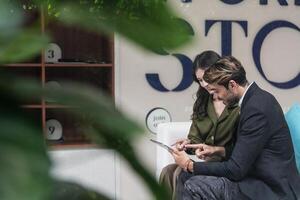 Business people talking at workplace office. Male and female colleagues enjoy relaxing and sitting on sofa. colleagues discussing about the project in the office. team of young people in office. photo