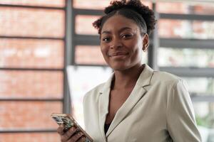 Portrait business african woman smiling and using smart mobile phone. headshot of an african american businesswoman. photo