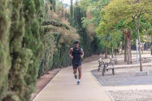 African American man in activewear jogging in park photo