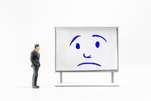 Miniature people, A dejected businessman is positioned in front of a white board, Blue monday concept photo