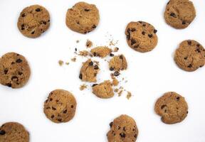 Chocolate chip cookies with focus on crushed chocolate chip cookies in the middle on white background photo