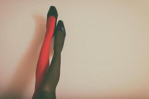 hermosa piernas de un mujer en en diferente color medias y alto tacones arriba en frente de pared.tonificada foto