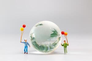 un alegre familia con un globo rodeando un cristal globo y el concepto de mundo tierra día foto