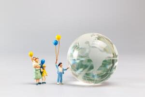 un alegre familia con un globo rodeando un cristal globo y el concepto de mundo tierra día foto