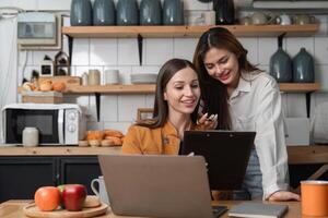 Two business women work together at home office Share your opinions about working online. photo