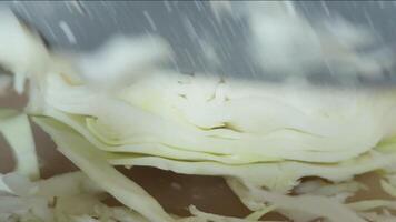 A cook in a home kitchen cuts cabbage with a knife on a cutting board. Close-up. video