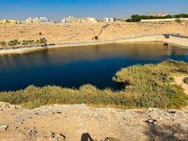 A beautiful daytime view of Wadi Namar Dam in riyadh , Saudi Arabia. The water of the dam and the surrounding hills are presenting a beautiful scene in the sunlight. photo
