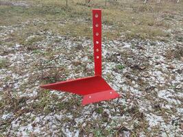 Red mini plow on a winter field photo