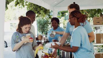 calentar comidas son dado a el desamparado por humanitarios mediante un sin ánimo de lucro organización. voluntarios distribuido gratis comida y esenciales a el necesitado durante un al aire libre comida conducir. trípode disparo. foto