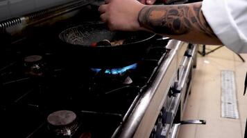 Cook frying seafood and shrimps in restaurant kitchen. Close up footage video