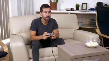 adulto uomo giochi un' video gioco su il consolle nel il vivente camera. rivelatrice dolly cursore 4k metraggio