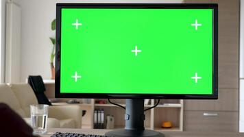 onherkenbaar Mens op zoek Bij modern persoonlijk computer met groot groen scherm chroma bespotten omhoog terwijl de TV in de leven kamer is Aan. dolly schuif 4k beeldmateriaal met parallax effect video