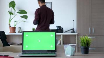 Laptop with an isolated chroma green screen on the desk in an living room. Dolly slider 4K footage video