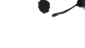 Black ink paint splashed over white textured background. Top view. Perfect assets for your motion graphics, transitions or other visual projects video