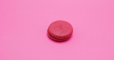 Big red macaroon on pick background in studio video