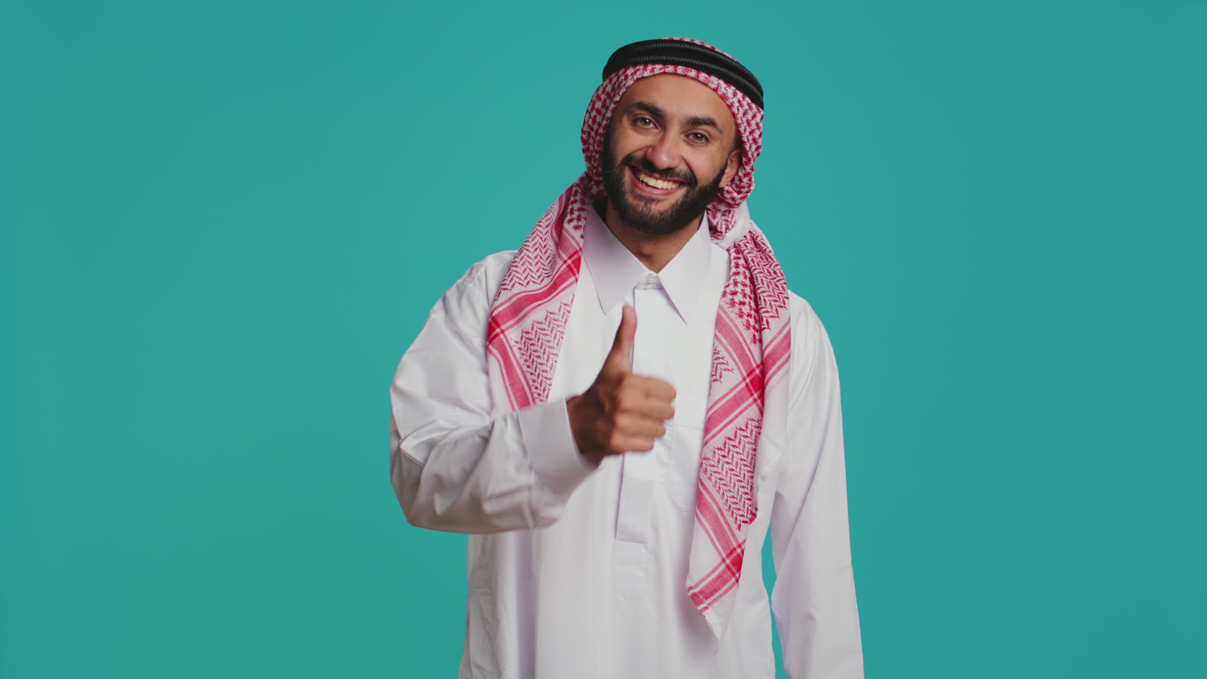 Middle eastern man does thumbs up on camera, showing agreement and  positivity while he wears traditional islamic clothes. Young smiling guy in  national arabic apparel, like symbol. 37762812 Stock Video at Vecteezy