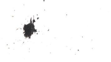 Multiple dots of black ink splashed over textured white background. Top view video