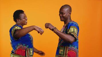 sucré couple en présentant cœur forme symbole dans studio, montrant leur l'amour pour chaque autre exprimer honnête émotions. africain américain marié gens mettant en valeur sincère sentiments avec romance signe. video