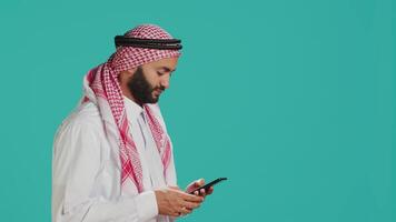 Islamic guy greeting friends on online call, waving and catching up with people on remote communicating network. Middle eastern man in national muslim clothes talking on videoconference. video