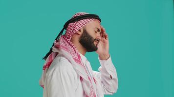 Middle eastern man being puzzled and thinking about solution, being interested about a subject and trying to find answer. Young adult being pensive in studio, wondering about new idea. video