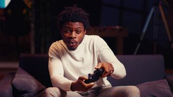 porträtt av bipoc gamer känsla Lycklig efter tar emot vinnare skärm på gaming trösta för dödande Allt fiender. stänga upp skott av förtjust spelare på Hem skrävel efter varelse segrande i TV-spel video