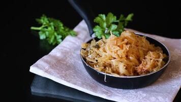 cabbage stewed with spices and carrots in a frying pan , video