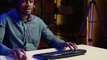 African american gamer engaging in online competitive multiplayer match using cutting edge gaming setup. Close up shot of man at home captivating spectators during live broadcast, playing videogames video