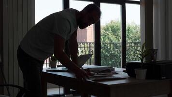 Silhouette of experienced employee working on his projects in his creative office. Writing a great idea. video