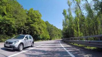 bil rider på asfalt berg väg med trafik. scen. berg lindning Spår med bil trafik och skön visningar av berg backe med grönska i sommar video