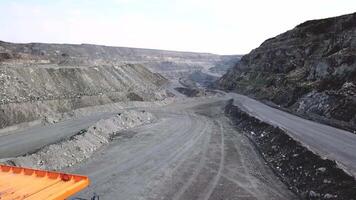 Top view of quarry dump truck. Dump truck traveling on dusty roads of open pit extraction of minerals. Heavy transport in extractive industry video