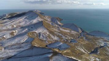 Winter Landschaft im das Bucht von das Nord Meer. Schuss. das Hügel sind bedeckt mit ein Schicht von Schnee gegen ein Blau Himmel. video