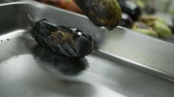 The chef with white-gloved hands shifts fried vegetables from the grill into a large container video