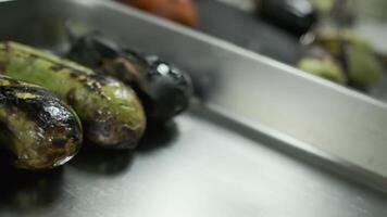 The chef with white-gloved hands shifts fried vegetables from the grill into a large container video