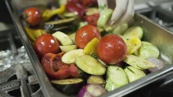 The chef puts chopped vegetables on the grill with his white-gloved hands video