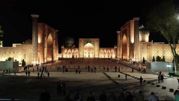 Drone panorama of the illuminated Registan complex at night, Samarkand, Uzbekistan video