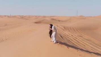 giovane barbuto uomo vestito come un' sciamano danza su deserto sabbia video