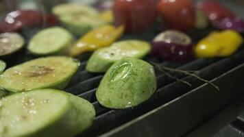 el cocinero pone Cortado vegetales en el parrilla con su guantes blancos manos video