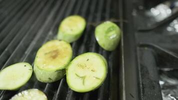 le chef met haché des légumes sur le gril avec le sien gants blancs mains video