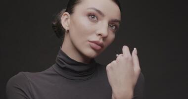 portrait tournage de une Jeune femme dans une studio sur une noir Contexte video