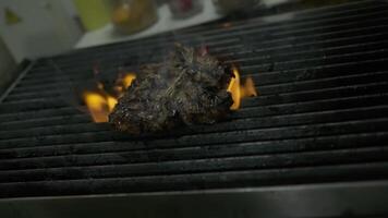 uma chefe de cozinha lança pedaços do manteiga em uma grelhado carne pilha com uma fogo video