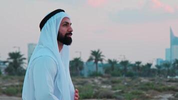 Portrait of a young bearded businessman in national Arab clothes talking on the phone. video