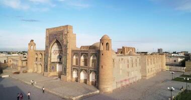 une drone en volant plus de un ancien complexe oulougbek madrasa. vieux Boukhara, Ouzbékistan. nuageux journée. video