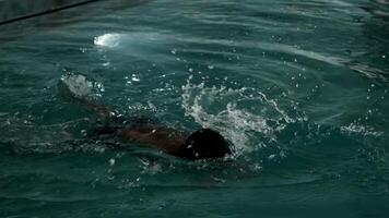 un' giovane atletico uomo con un' giovane figlio nuotate nel il piscina di un costoso lusso Hotel. video
