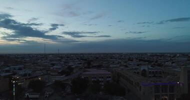 de Drönare flugor på natt över de vatten Nästa till de kolonner av de gammal komplex bolo khauz. gammal bukhara, uzbekistan. video