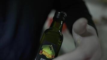 uma luva branca chefe de cozinha abre uma garrafa do Oliva óleo video