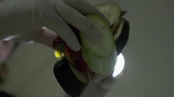 A chef in white gloves throws vegetables cut into pieces video